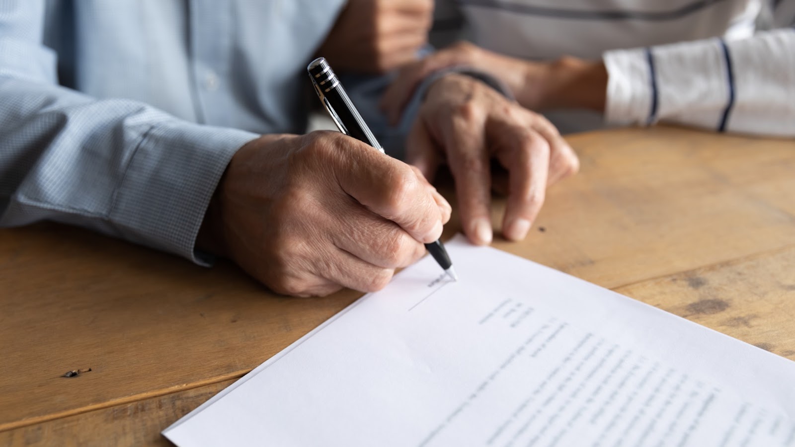 a man signs a piece of paper 