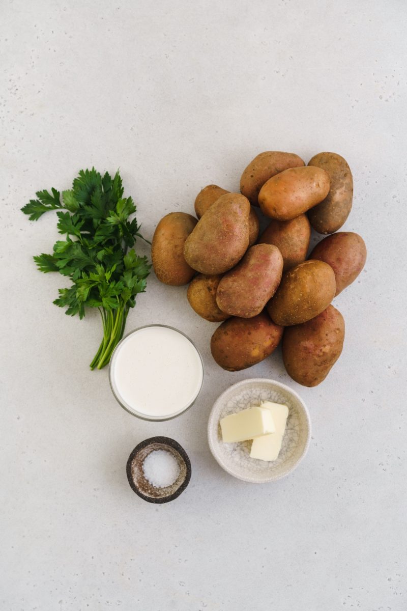 Red skin mashed potatoes with butter and parsley on a white background.