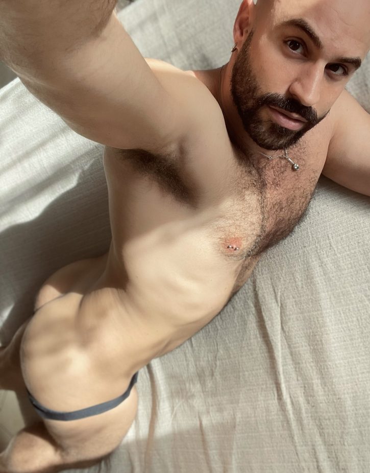 Mister Caccamo naked lying on his stomach on the bed showing off his gay bubble butt with his grey underwear pulled down to reveal his naked body