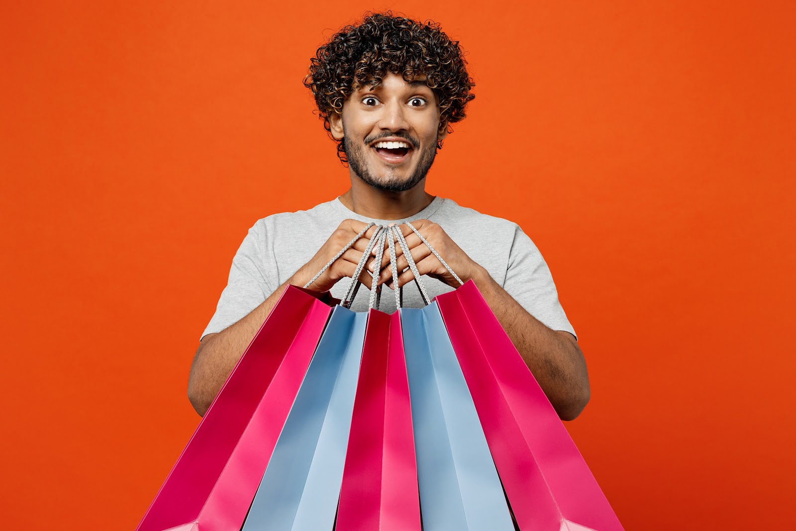 a man holding different colored shopping bags