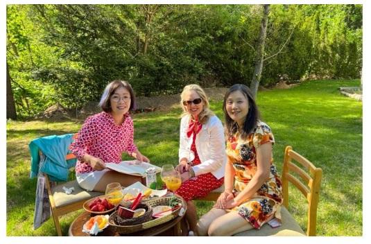 A group of women sitting outside

Description automatically generated