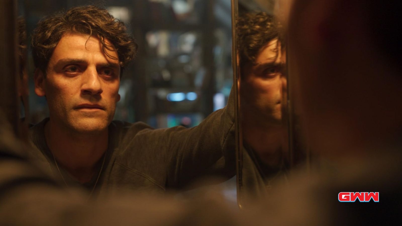 Oscar Isaac as Marc Spector staring at his reflection in Moon Knight