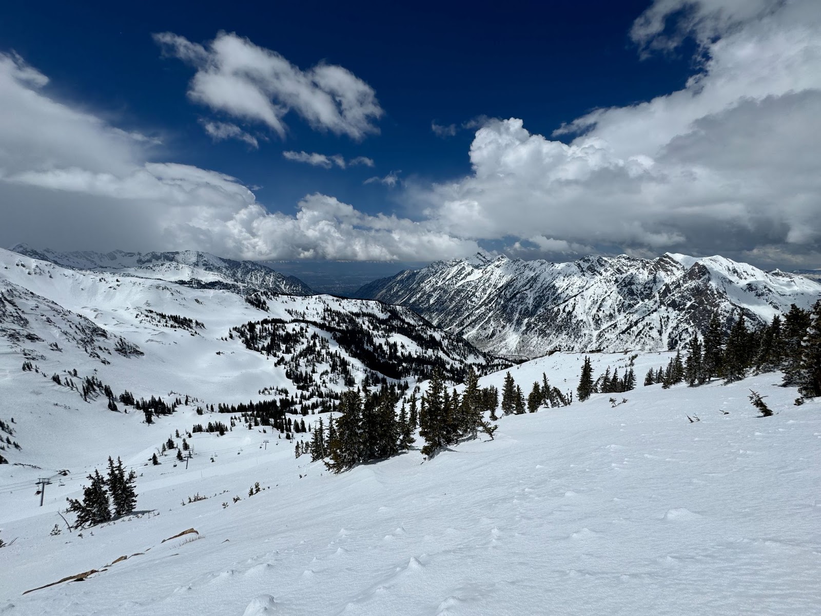 Snowy ski slopes with the Salt Lake Valley in the background, seen from the top of Snowbird