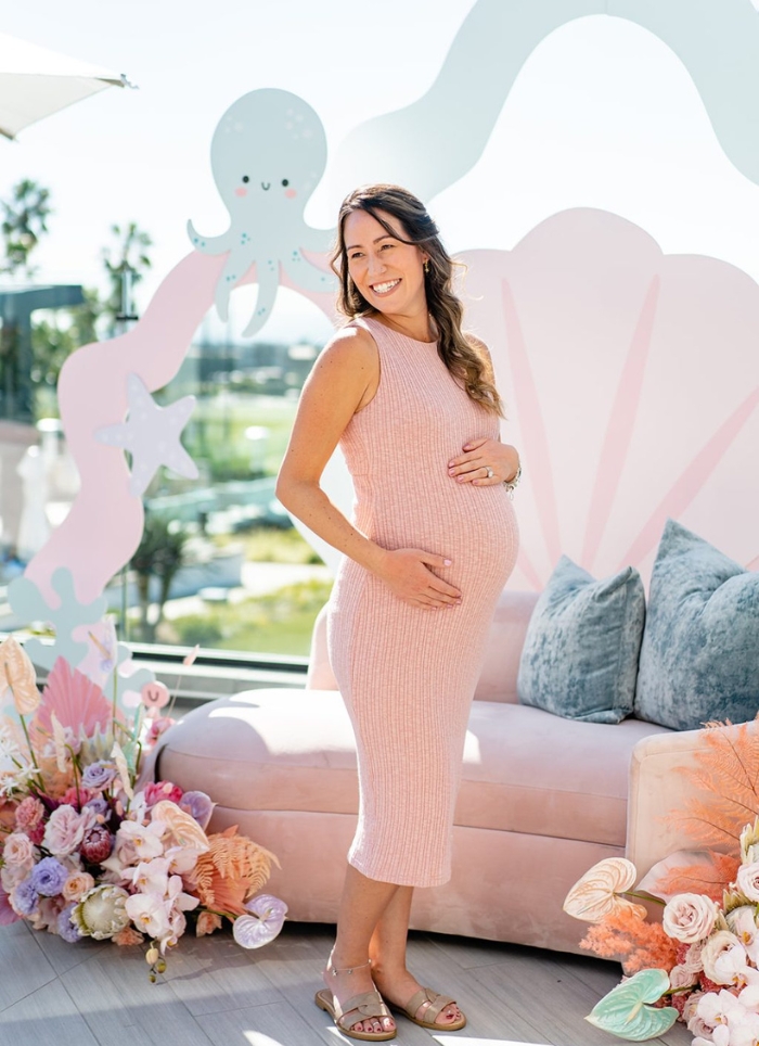 pregnant woman in pink dress at pink sea themed baby shower