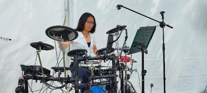 A person playing a drum setDescription automatically generated