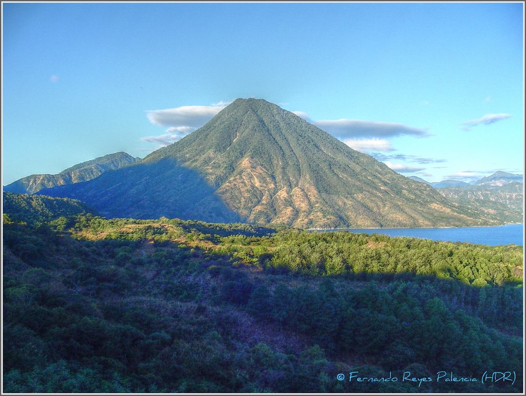 There are plants and trees all throughout Guatemala's Volcán San Pedro. a scene that embodies the highland region's natural elegance. Above the mountain, the sky looks cloudy.