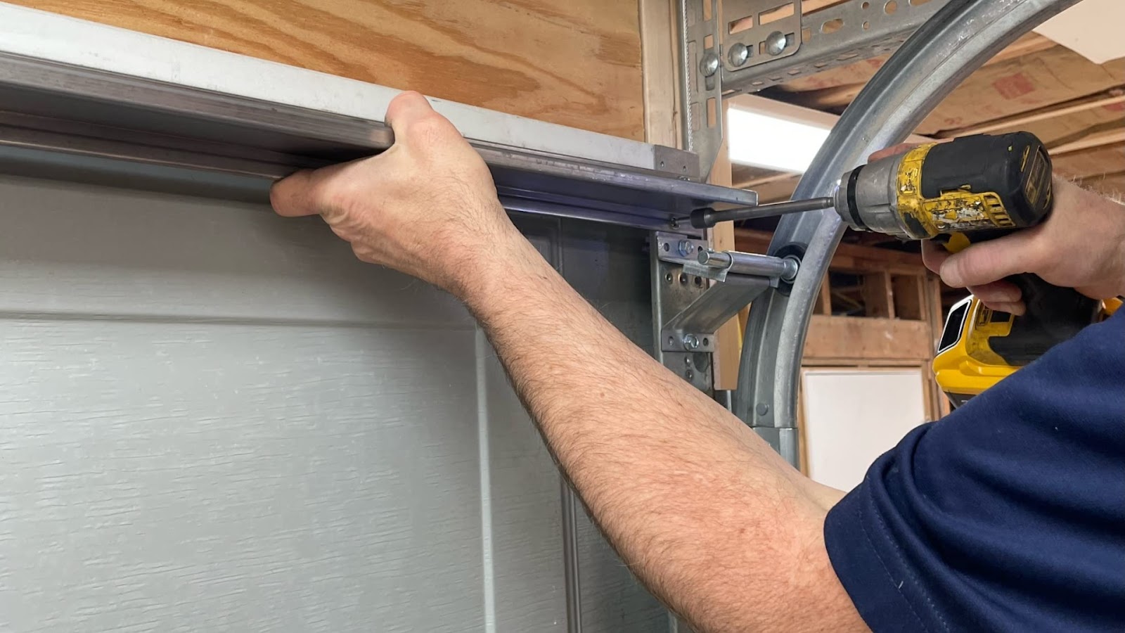 A garage door technician installing garage door reinforcement struts