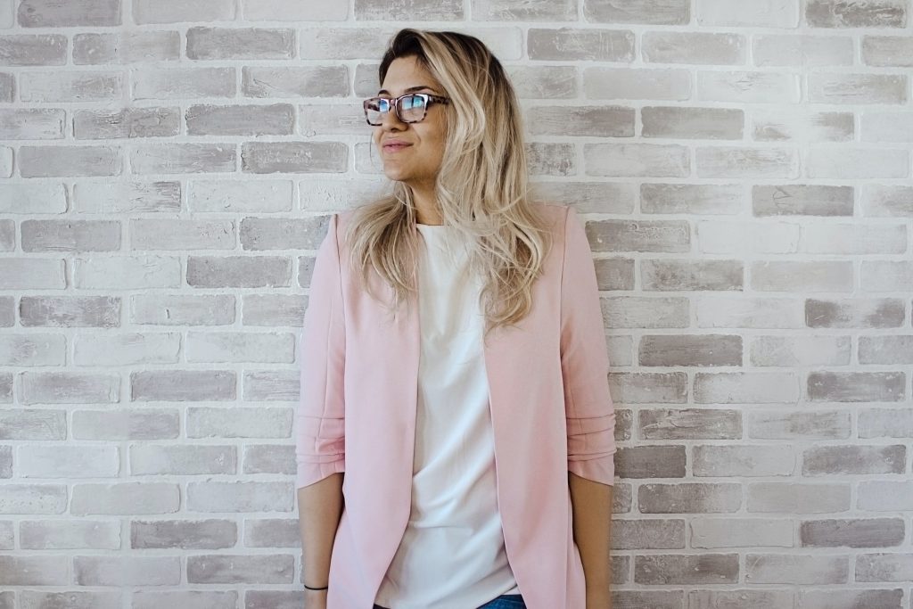 Female coach standing against grey wall