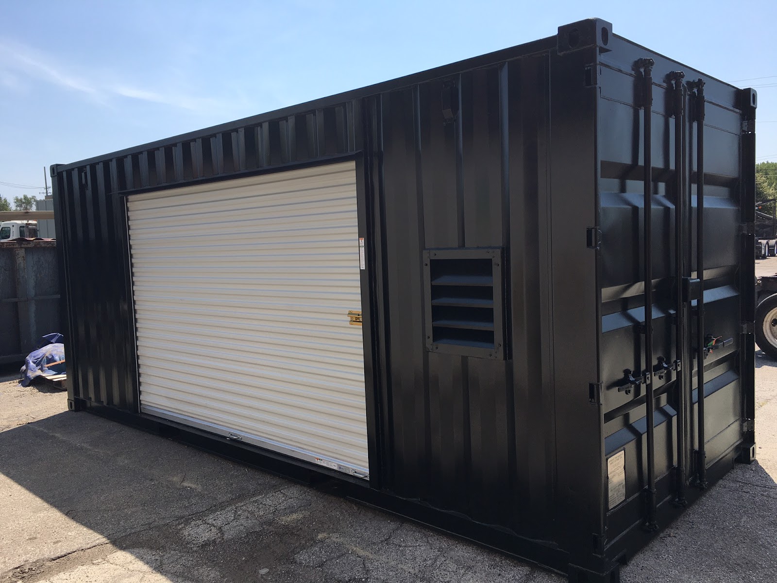 black shipping container storage with garage door