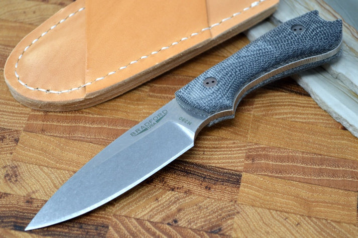 An image featuring the Guardian 3 next to a tan leather sheath on a wooden background.