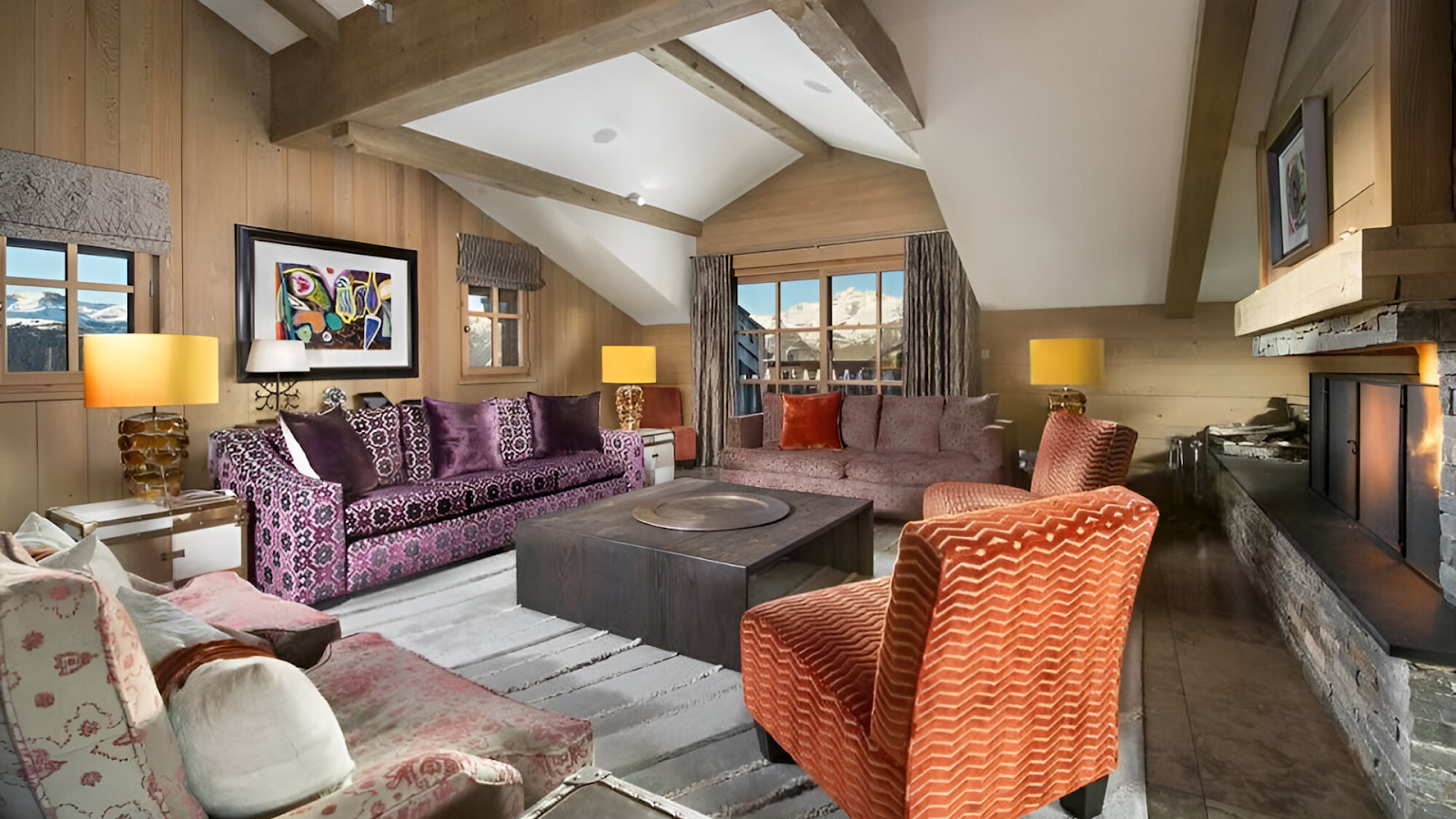 The living room of a luxury vacation rental adorned with patterned couches, artworks, and other furniture. | Photo credit: Chalet Ivoire