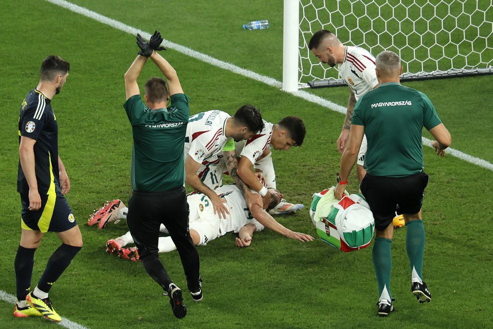 Varga, da Hungria, cai desacordado aps choque de cabea em jogo com Esccia, na Eurocopa, e mdico faz sinal de concusso  Foto: Ronald Wittek/EFE