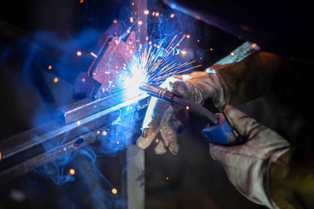 Metal welding. Fire from operation of welding machine. Manufacture of steel seam. Processing of steel profile. Sparks from welding. Metal welding. Fire from operation of welding machine. Manufacture of steel seam. Processing of steel profile. Sparks from welding. Smash in dark in workshop. welding power supply stock pictures, royalty-free photos & images