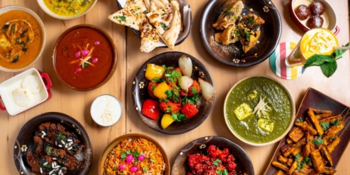 Various types of food displayed on a table, including fruits, vegetables, meats, and desserts.