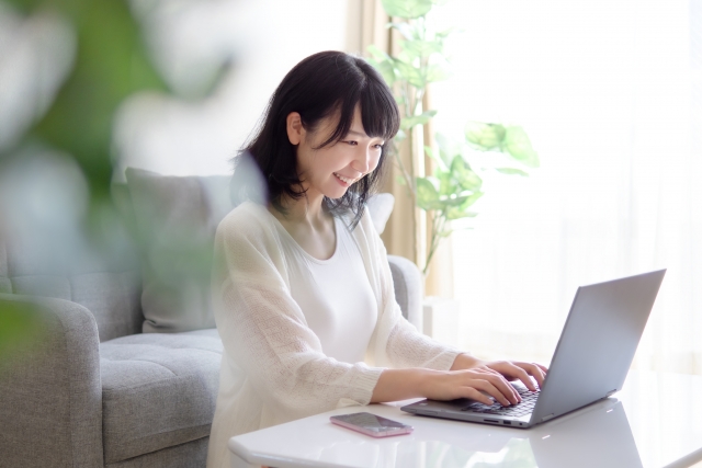 パソコンで物件探しをする女性