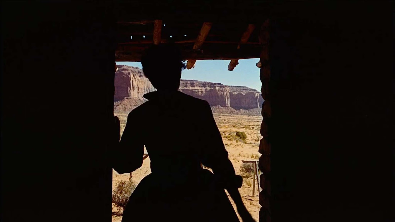 A silhouette of a person in a doorway Description automatically generated