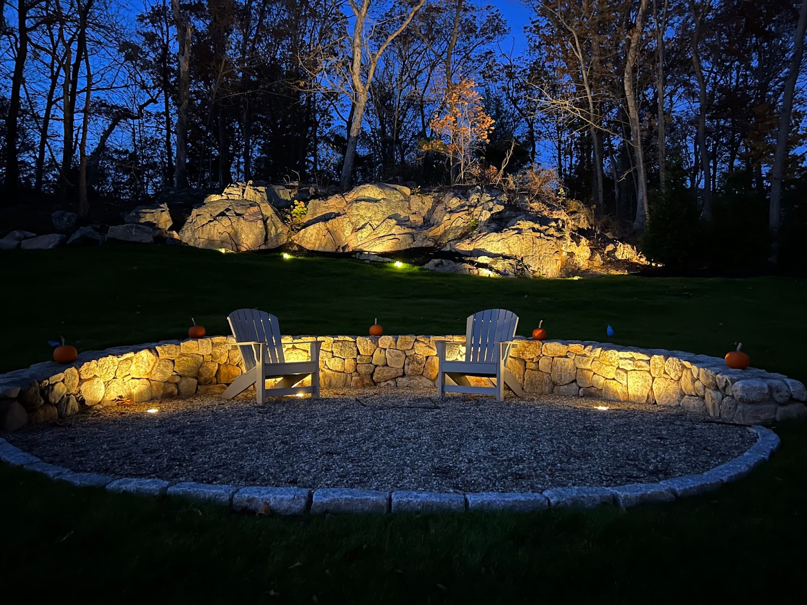 Landscape lighting in Winchester, MA around a built in fire pit