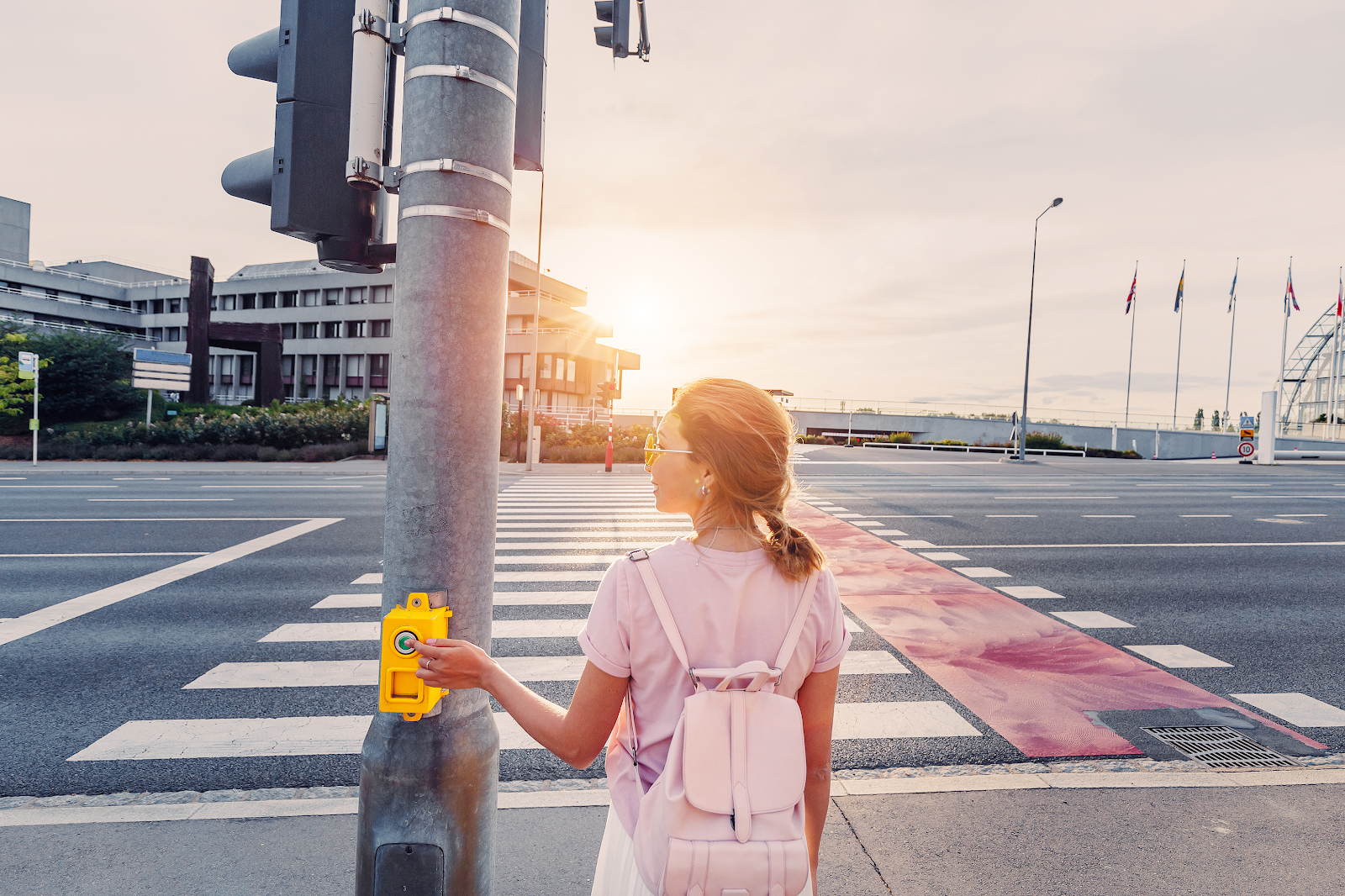 school girl pressing the crosswalk button infront of a cross walk, many pedestrian accidents happen due to driver negligence