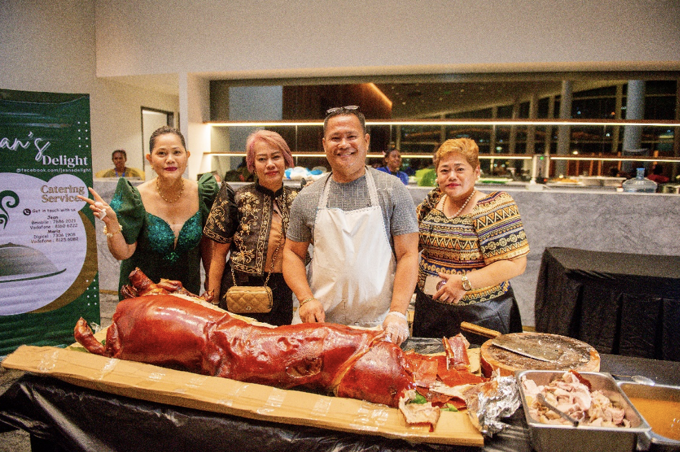 A group of people standing around a large pigDescription automatically generated