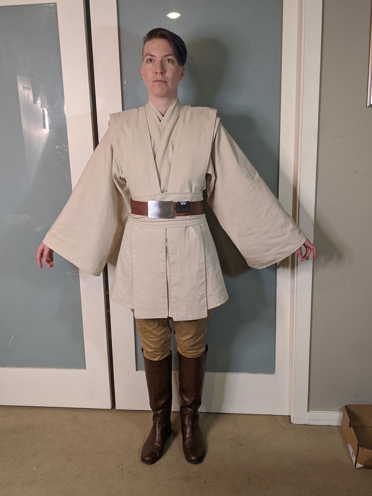 Image description: A person in a Jedi costume, facing forward, with their arms extended down and to the sides /end description