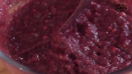 A bowl containing Falsa berries, sugar, black salt, and roasted cumin powder being mashed together to extract juice.