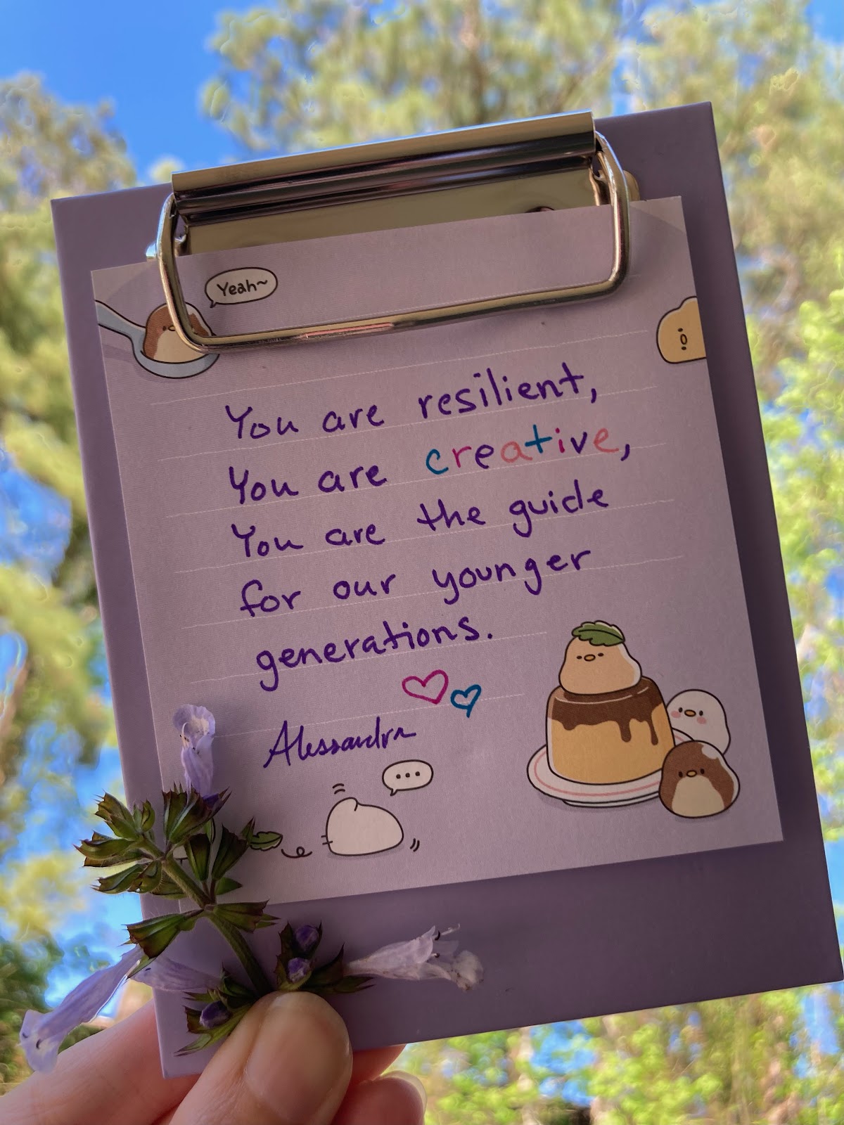 A handwritten note from Alessandra on light purple note paper that reads: "You are resilient, you are creative, you are the guide for our younger generations." 