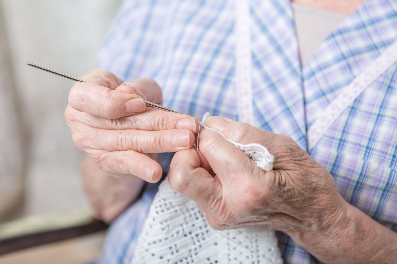 A close-up picture of a senior crocheting.