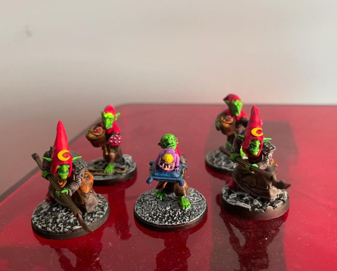 A group of small figurines on a red surface  Description automatically generated