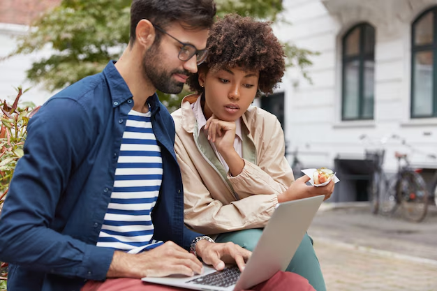 Two people searching something on a laptop