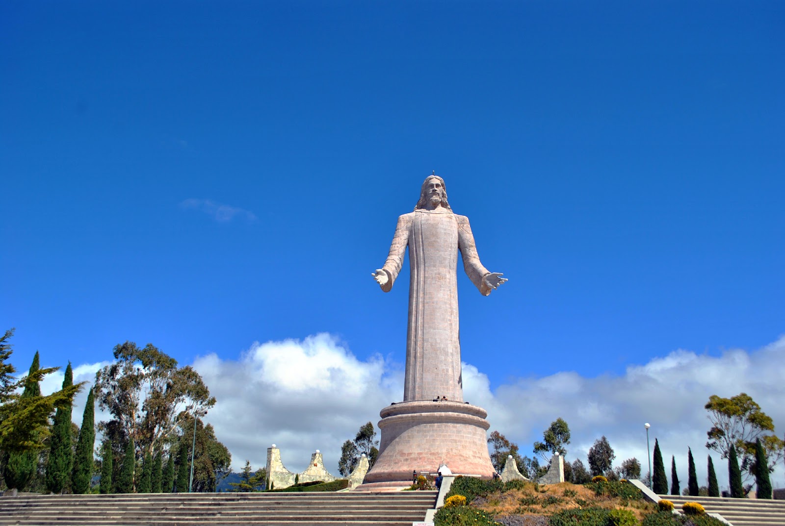 The Cristo Rey statue, representing Jesus Crist, under a serene blue sky.