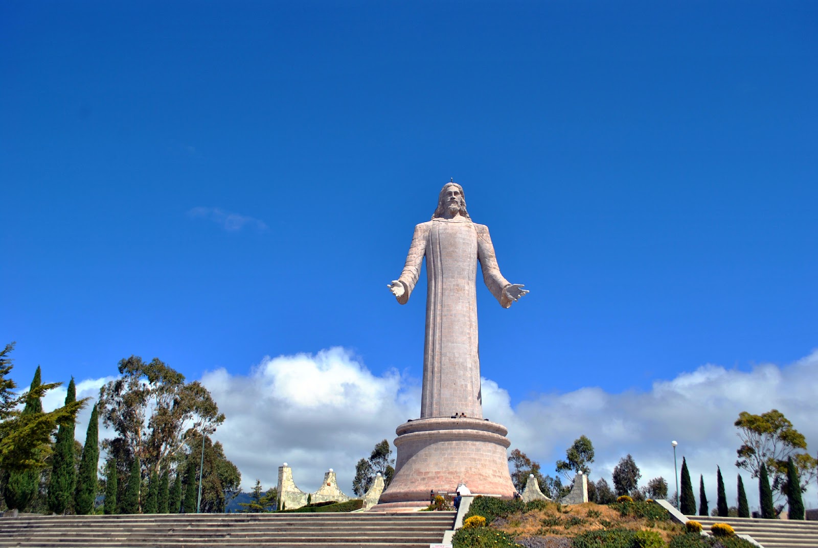 The Cristo Rey statue, representing Jesus Crist, under a serene blue sky.