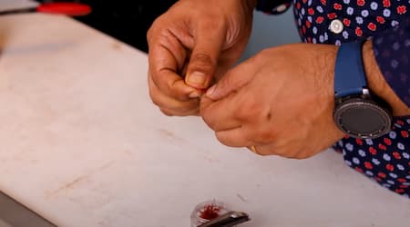 Adding saffron strands to the boiling tea as a final aromatic touch.