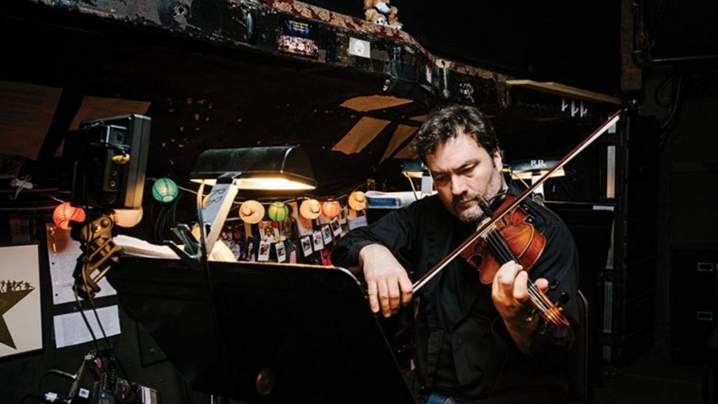 Jonathan Dinklage playing the violin