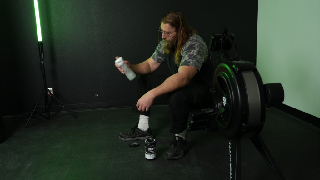 A BarBend tester shaking up creatine after a workout.