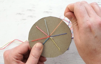 A person tying a string on a circular object

Description automatically generated