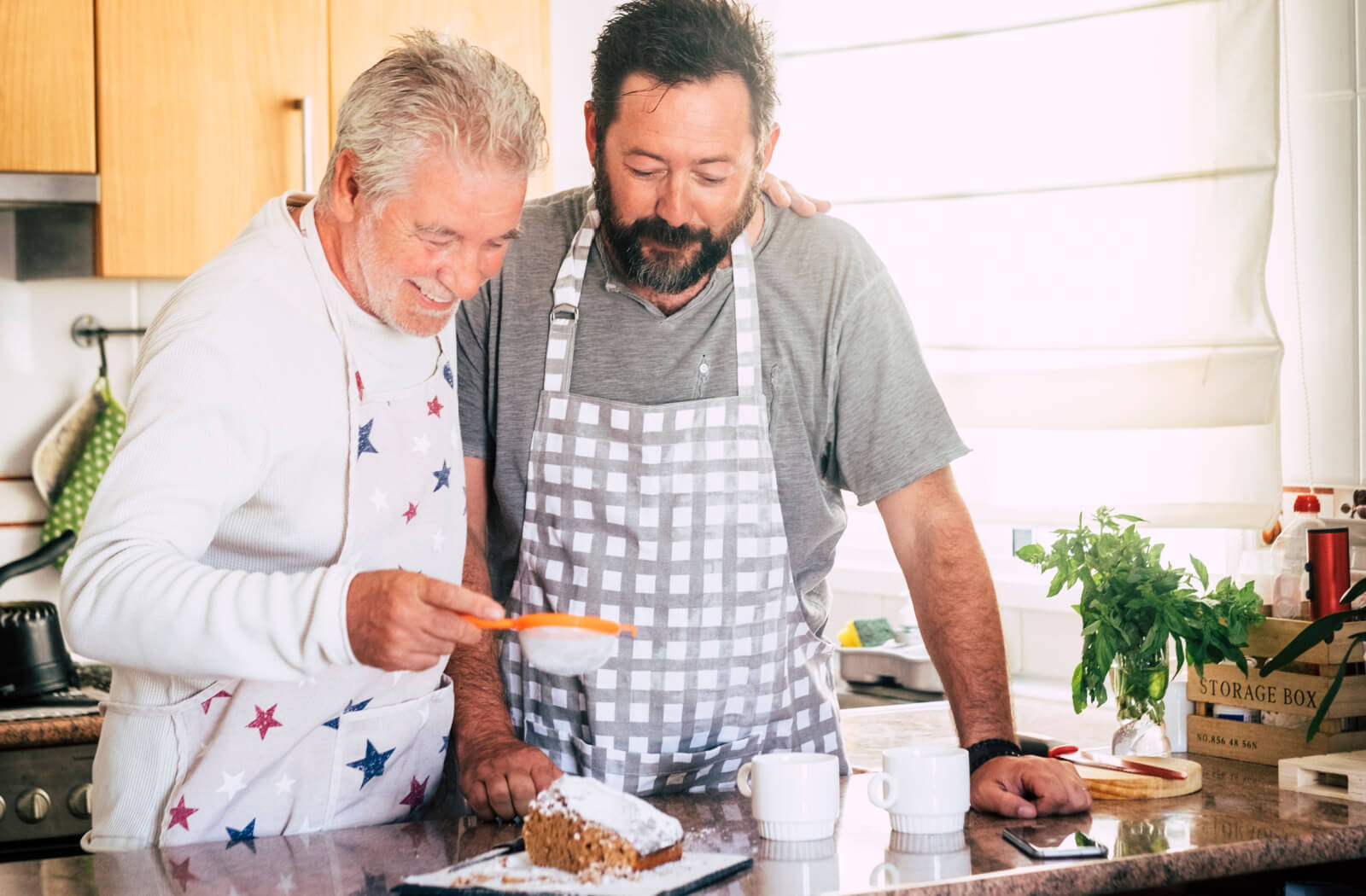 n older adult showing and a man preparing a cake together.