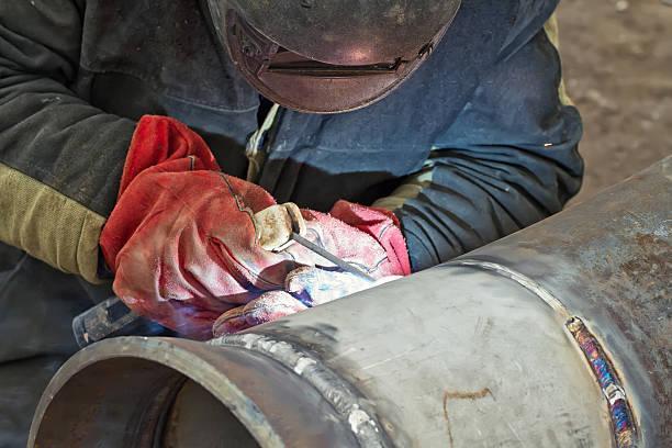 welder performs welding works on pipelines stainless steel