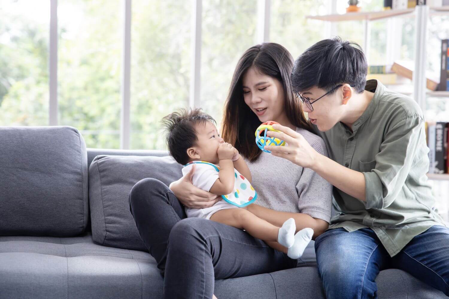 An infant sitting on the lap of his adoptive parents