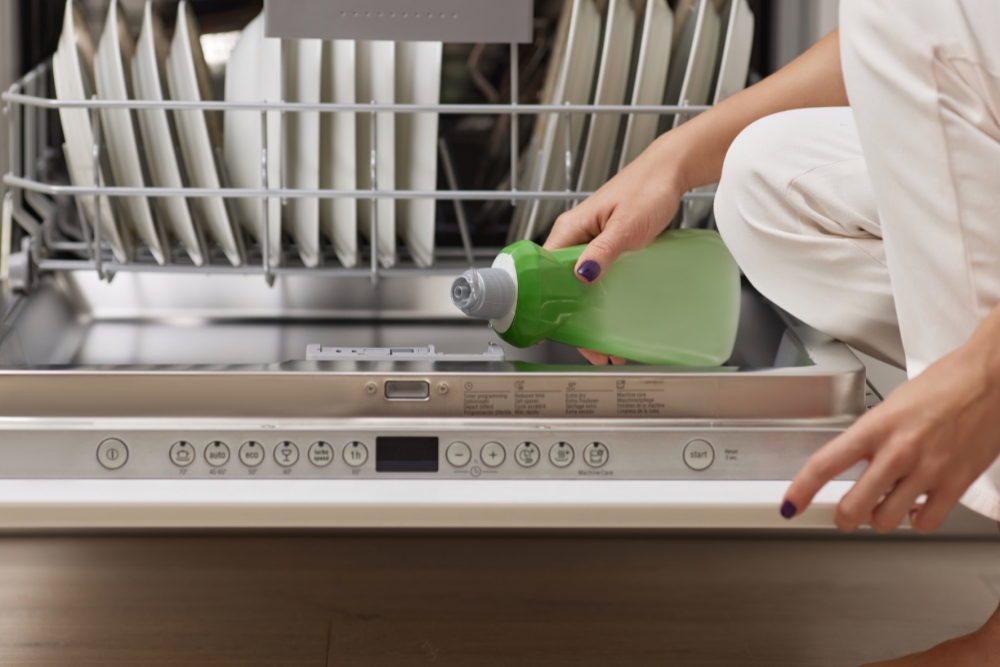 Women pouring dishwasher liquid to clean dishes.