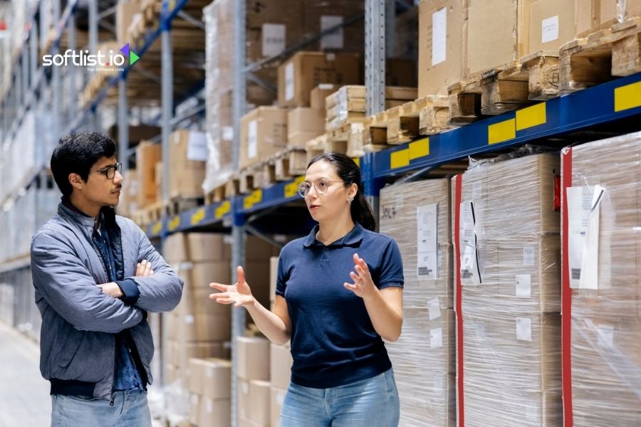 Two professionals discussing in a warehouse setting.