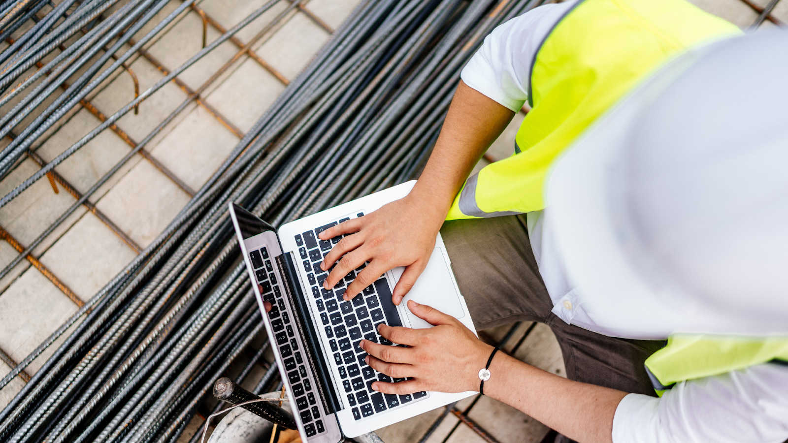 Construction worker using laptop on construction site.