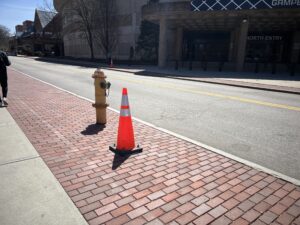 
An orange traffic cone where a light pole used to be in front of Gampel Pavilion / Julliana Bravo