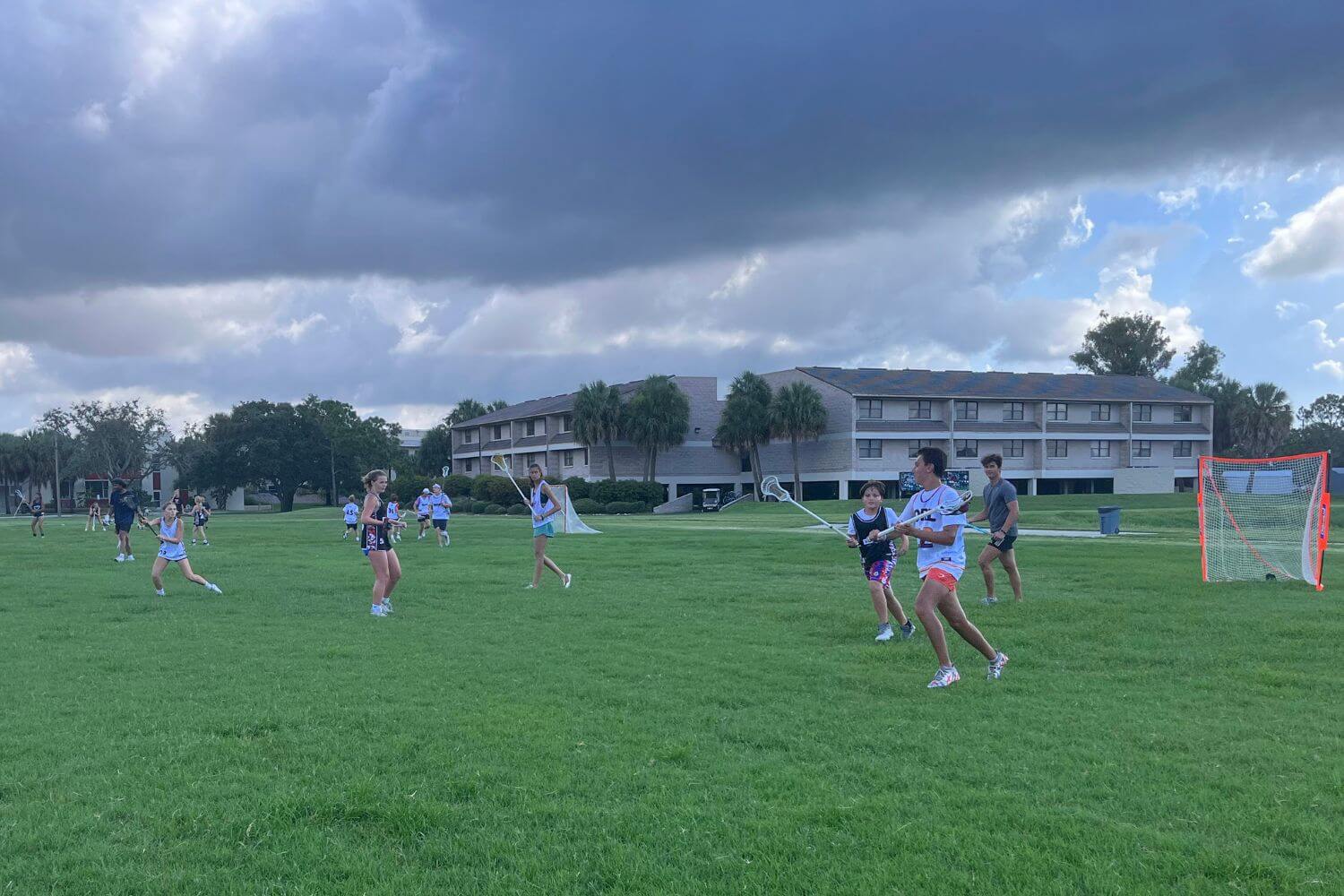 Youth lacrosse players on the field during an end-of-summer tournament at sports camp