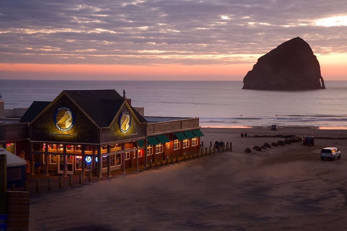 Pelican Brewing Company at Cape Kiwanda at sunset with large Haystack Rock in the ocean in the background