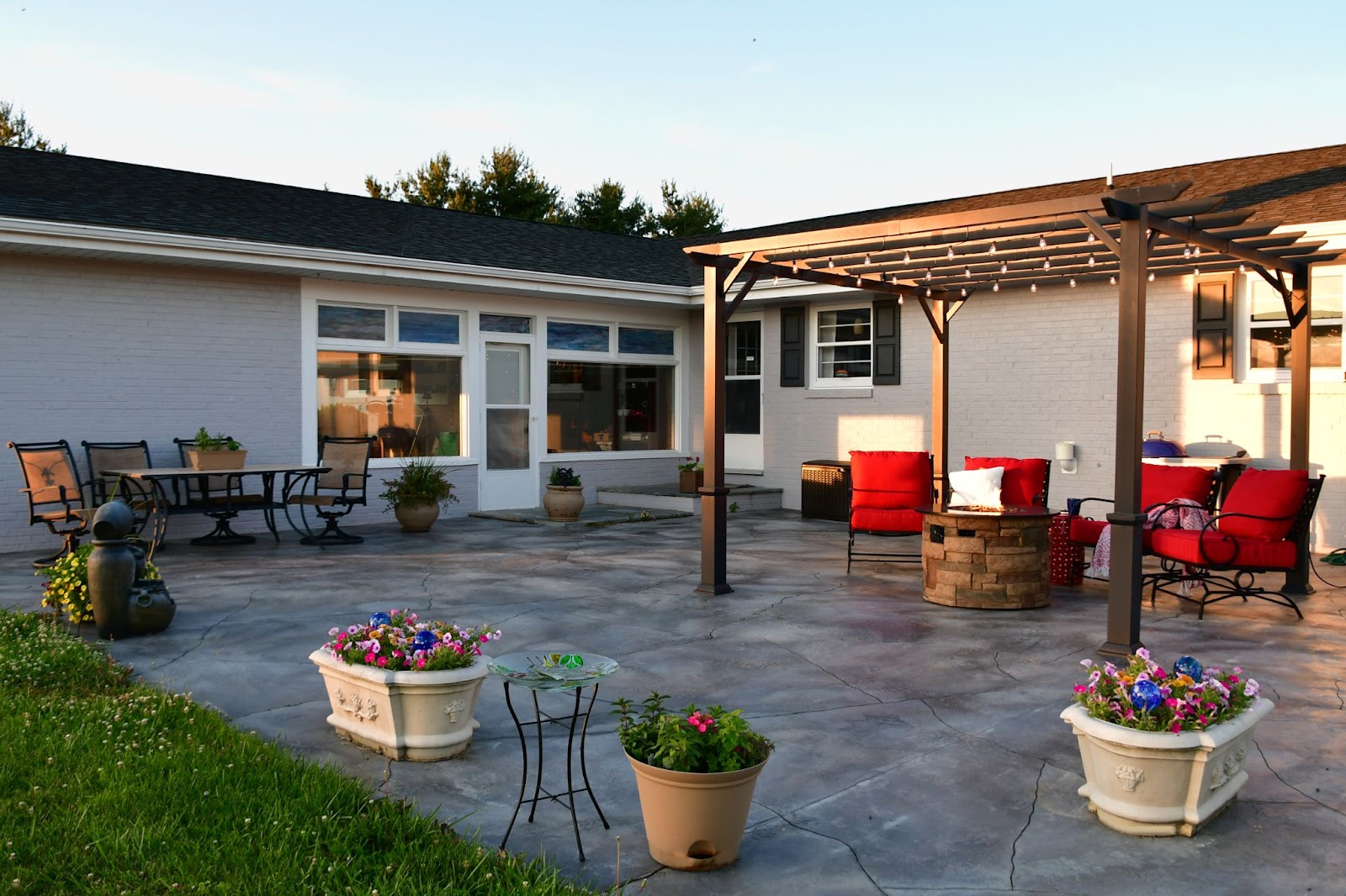 Patio space with concrete, chairs, an awning, and a fire pit. 