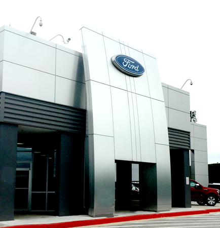 Front view of a Ford-branded pre-engineered steel auto shop with a modern facade and entrance.