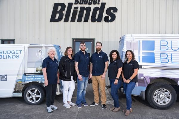 Group of workers in front of building that says "Budget Blinds"