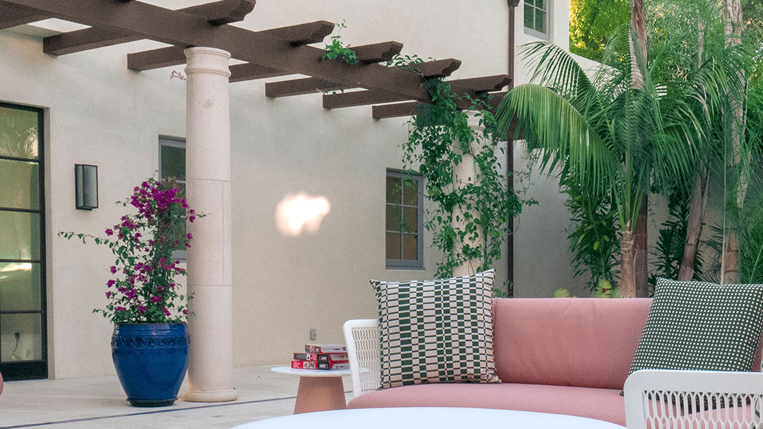 A pergola lined with planters adorns a cozy and relaxing patio
