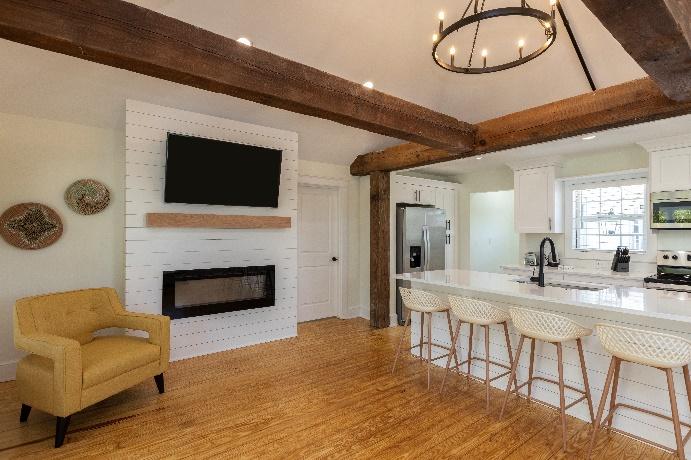 A room with a kitchen and a bar

Description automatically generated