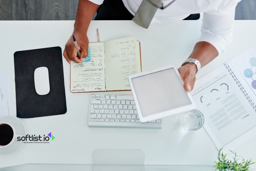 Businessman working at a desk with a notebook and tablet.